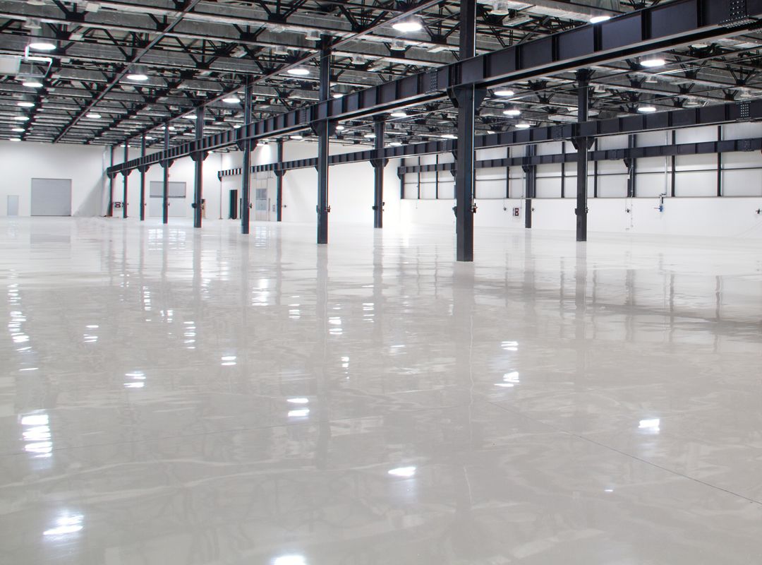 Commercial Epoxy Flooring in Bergen County - NJ being applied as a crew coats a prepared warehouse aisle