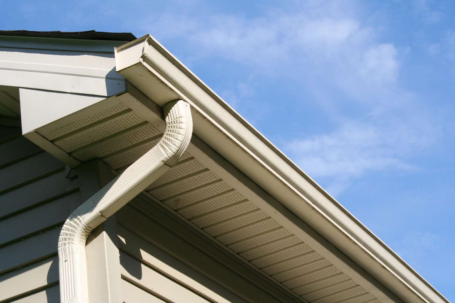 Technician completing gutter installation on a Bergen County - NJ home while checking pitch and downspout alignment