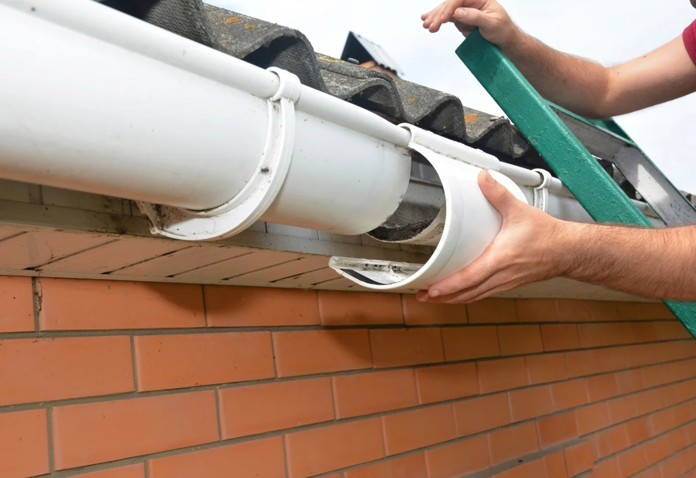Technician completing gutter installation on a Bergen County - NJ home while checking pitch and downspout alignment