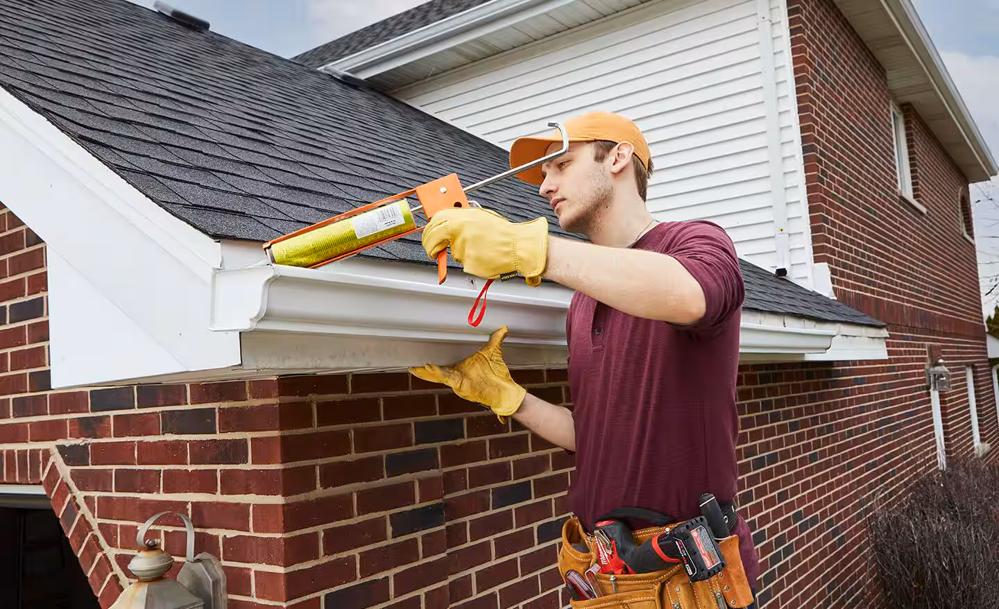 Technician completing gutter installation on a Bergen County - NJ home while checking pitch and downspout alignment