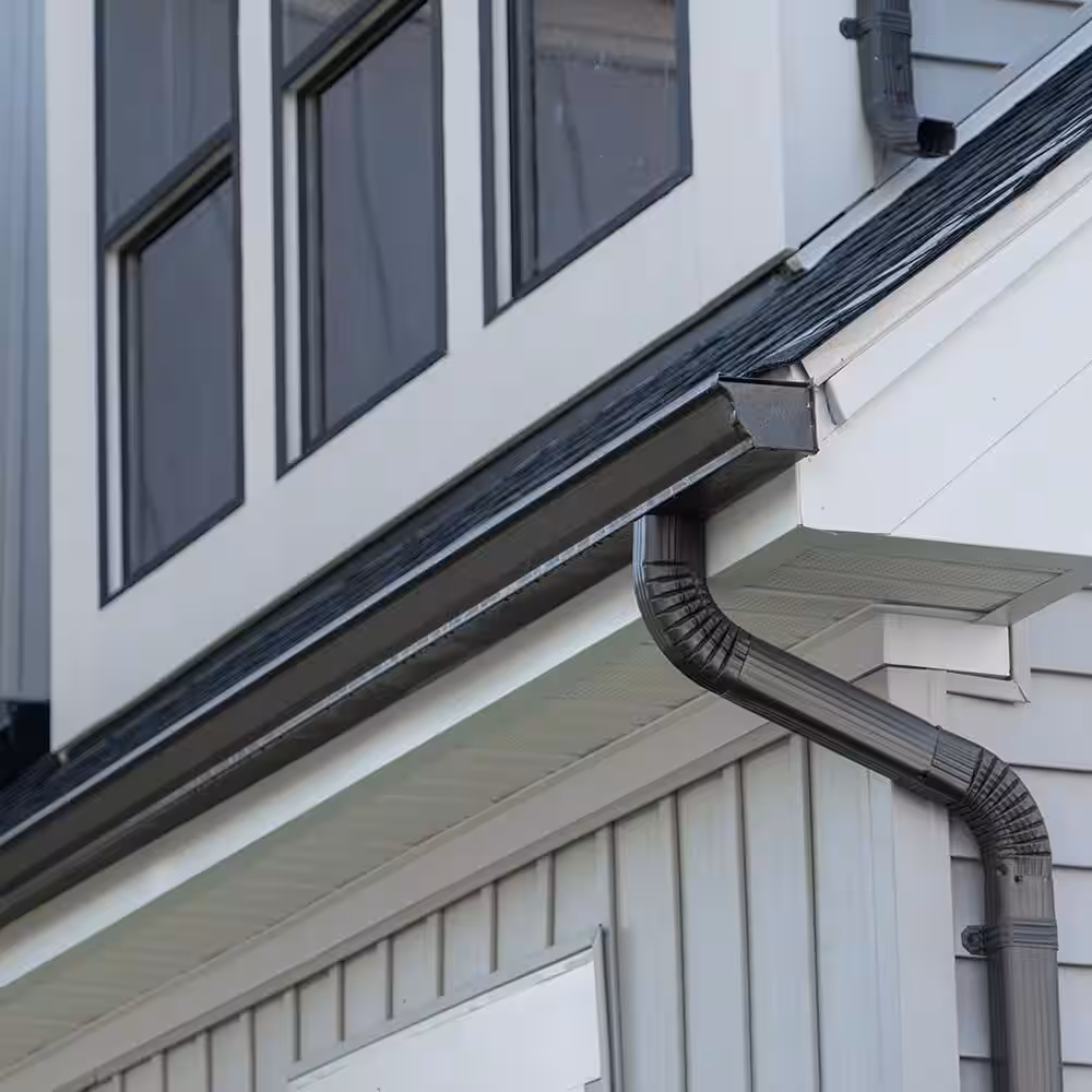 Gutter Installation in Bergen County - NJ underway as a crew aligns new seamless gutters along a roof edge